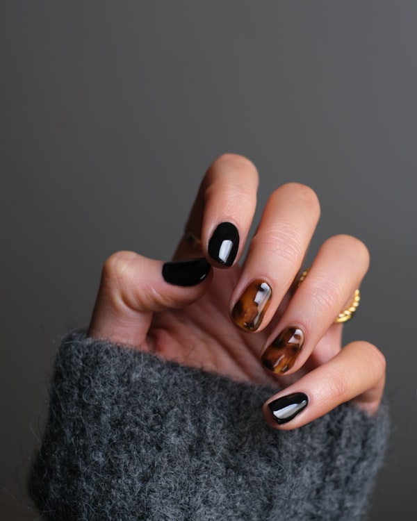Glossy black and tortoiseshell manicure close-up